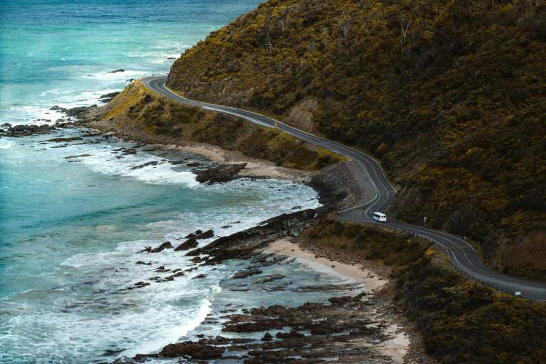 Foto tomada con el DJI neo 2, una carretera pegada a la montaña y de fondo el mar