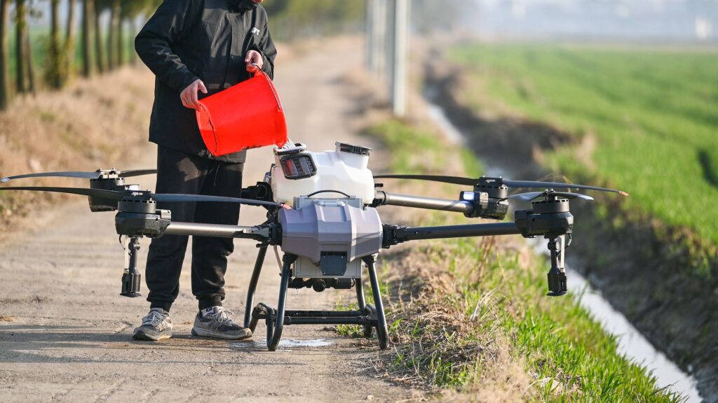 operador de drones, rellenado dron con semillas para cultivo agrícola